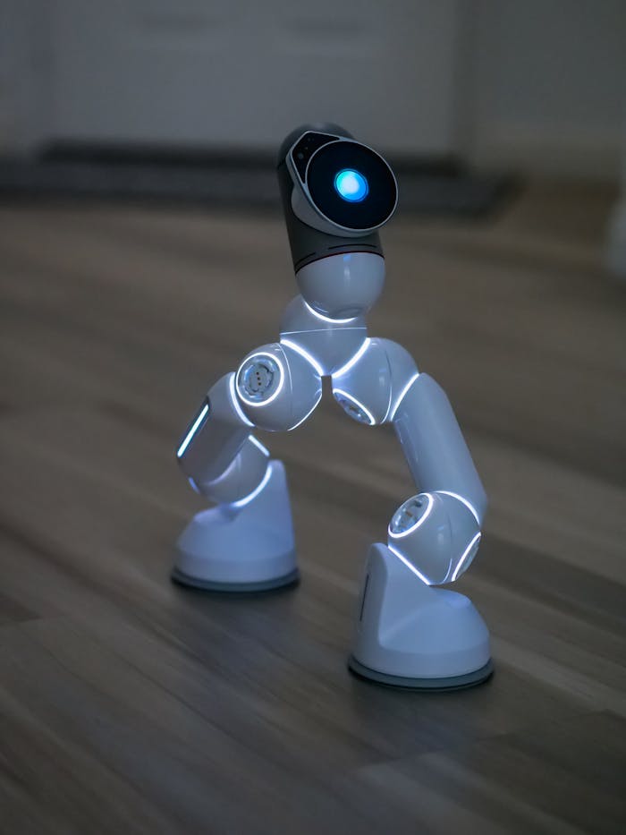 Close-up of a futuristic AI robot with illuminated joints on a wooden floor.